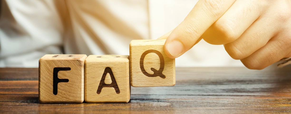 Businessman puts wooden blocks with the word FAQ (frequently asked questions). Collection of frequently asked questions on any topic and answers to them. Instructions and rules on Internet sites